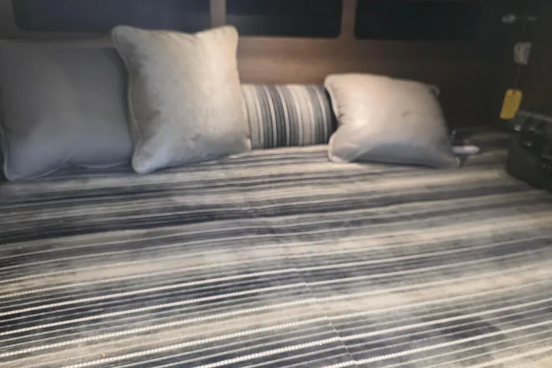 Slide: The Image of Interior of 2017 Monterey 360 Sport Coupe with striped bedding and cushions. - 29