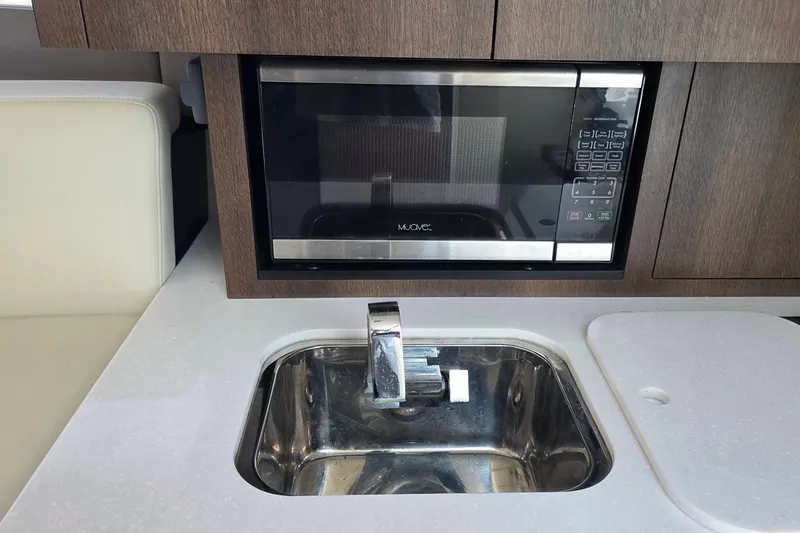 Slide: The Image of Modern kitchen area in 2017 Monterey 360 Sport Coupe with microwave and sink. - 31