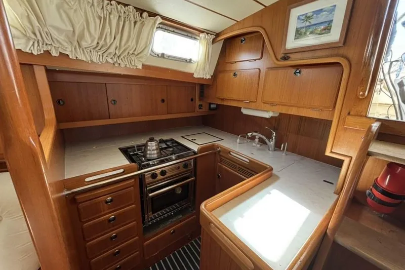 Slide: The Image of Hallberg-Rassy 46 yacht kitchen, 2000 model, featuring wooden cabinetry and modern appliances. - 10