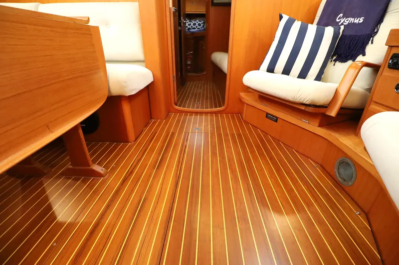 Slide: The Image of Interior of 2000 Hallberg-Rassy 46 yacht with wooden flooring and cushioned seating. - 14
