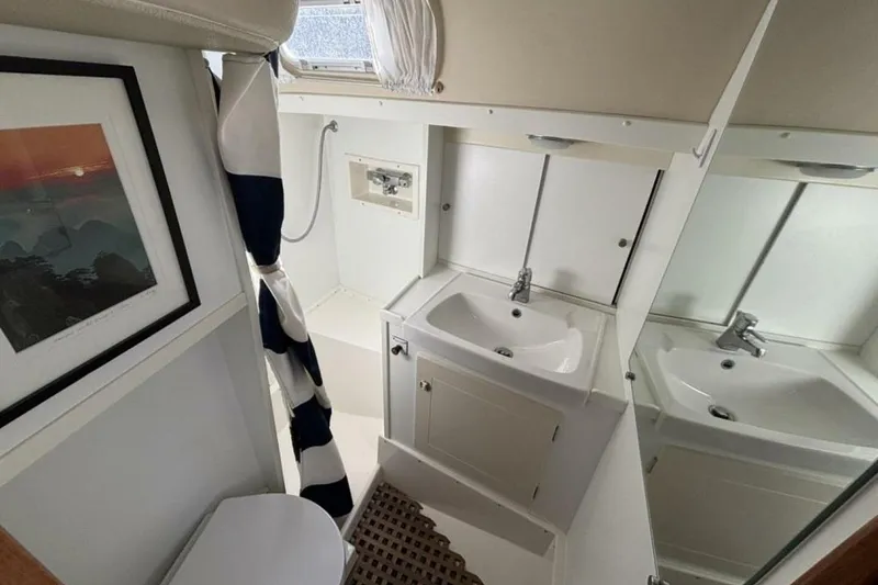 Slide: The Image of Hallberg-Rassy 46 yacht bathroom, featuring sink, mirror, and nautical decor, year 2000 model. - 16