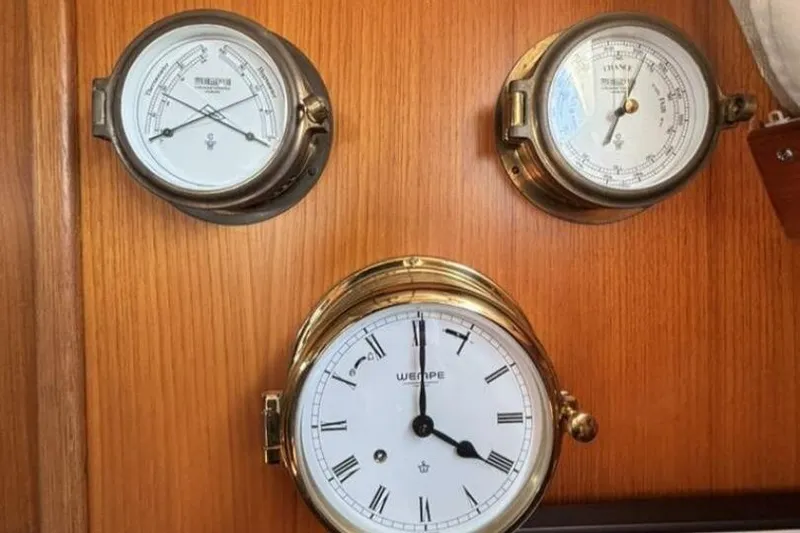 Slide: The Image of Brass nautical instruments on Hallberg-Rassy 46 yacht, 2000 model, featuring clock and barometers. - 18