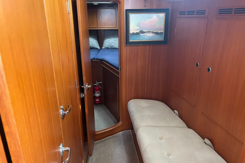 Slide: The Image of Hallberg-Rassy 46 yacht interior, featuring wooden paneling, a cozy cabin, and a framed painting. - 19