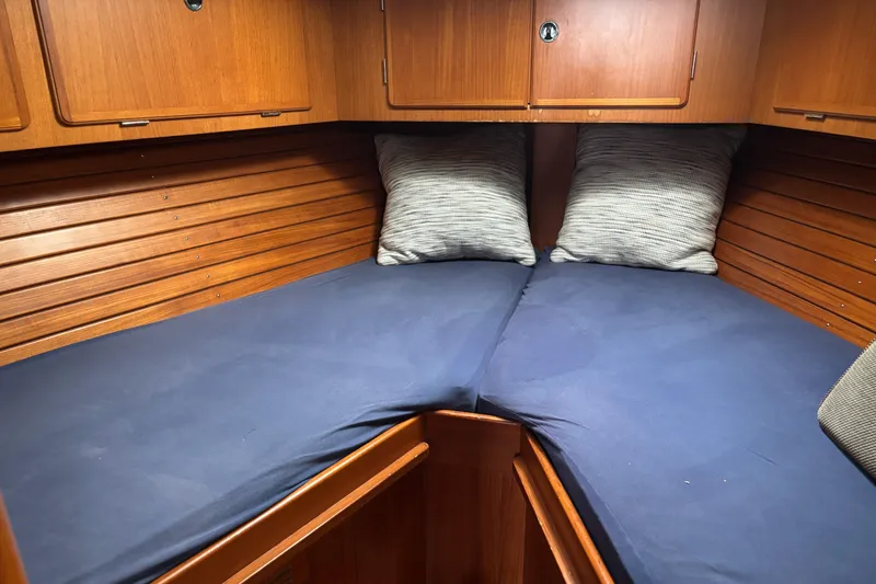 Slide: The Image of Cozy cabin interior of 2000 Hallberg-Rassy 46 sailboat with blue bedding and wooden finish. - 22