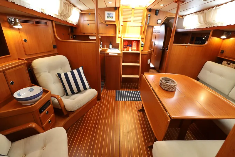 Slide: The Image of Luxurious interior of 2000 Hallberg-Rassy 46 yacht with wooden furnishings and cozy seating. - 6