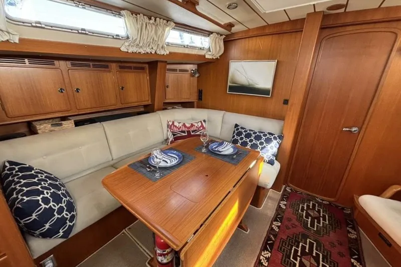 Slide: The Image of Interior of 2000 Hallberg-Rassy 46 yacht with cozy seating and wooden table. - 8