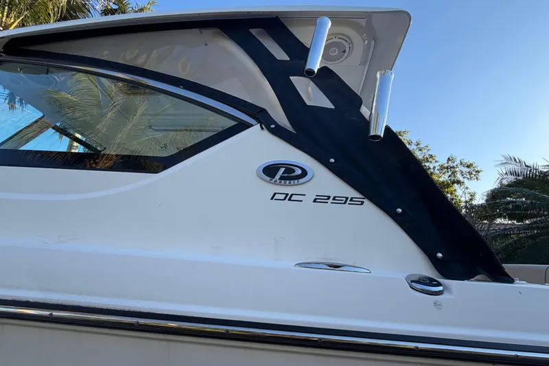 Slide: The Image of 2017 Pursuit DC 295 Dual Console boat side view with logo and palm trees. - 14