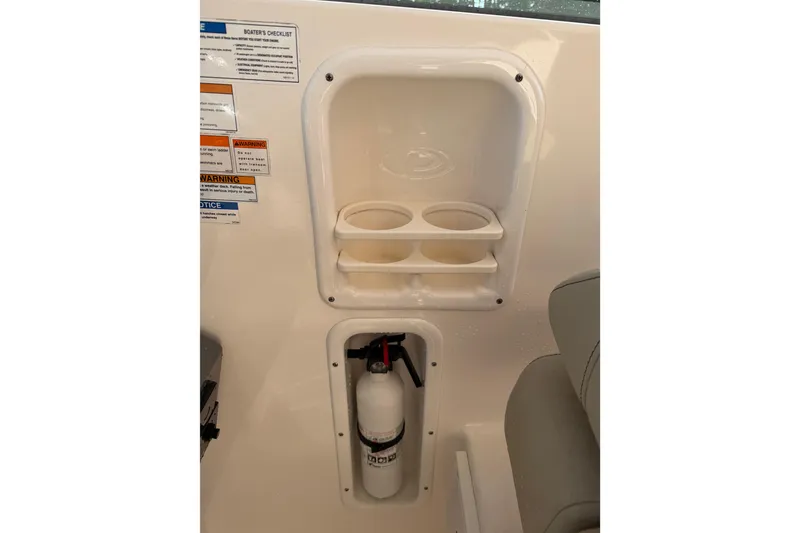 Slide: The Image of 2017 Pursuit DC 295 Dual Console interior with cup holders and fire extinguisher. - 27