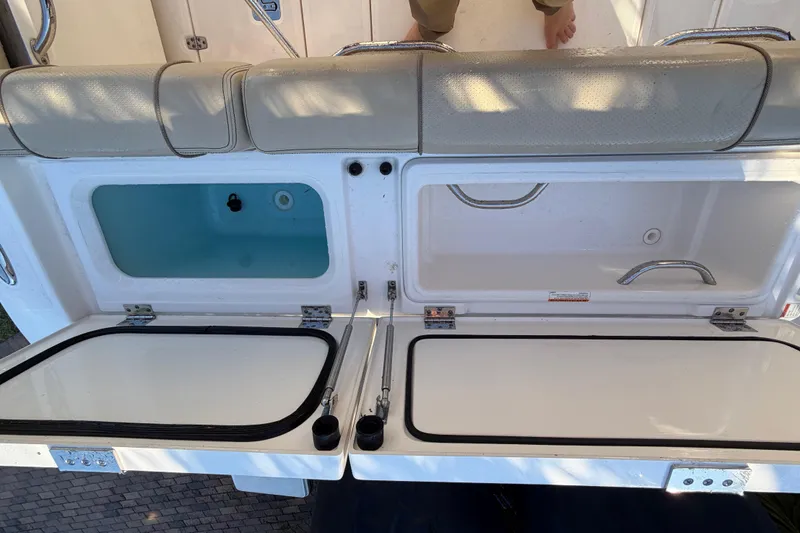 Slide: The Image of 2017 Pursuit DC 295 Dual Console boat storage compartments open, showcasing interior features. - 30