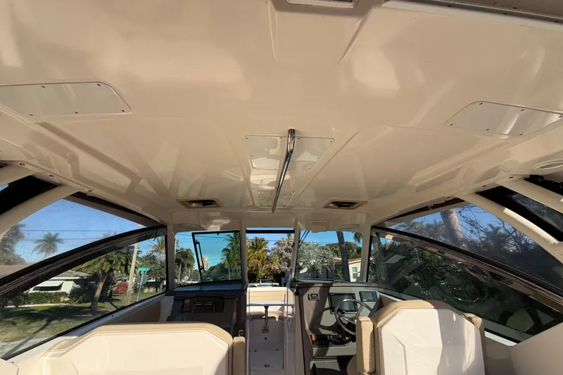 Slide: The Image of Interior view of 2017 Pursuit DC 295 Dual Console boat, showcasing helm and seating area. - 34