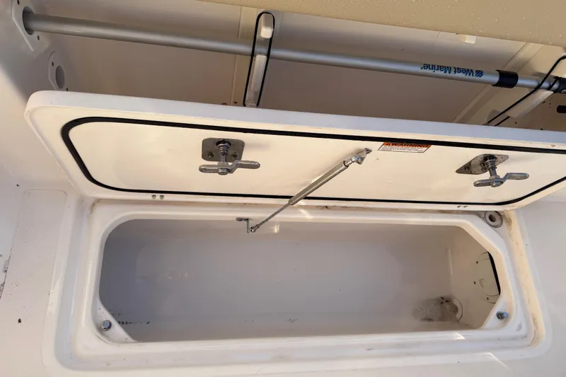 Slide: The Image of Open storage compartment on a 2017 Pursuit DC 295 Dual Console boat. - 42