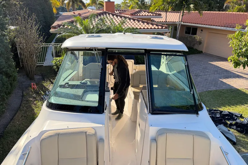 Slide: The Image of 2017 Pursuit DC 295 Dual Console boat parked near a house with a person onboard. - 47