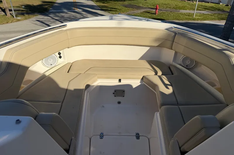 Slide: The Image of 2017 Pursuit DC 295 Dual Console boat interior with beige seating and speakers. - 50