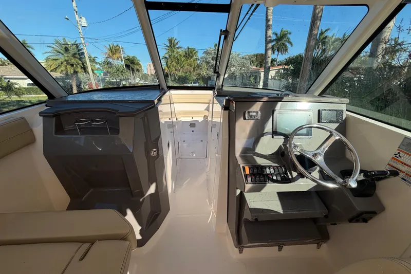 Slide: The Image of 2017 Pursuit DC 295 Dual Console boat interior with steering wheel and dashboard controls. - 51