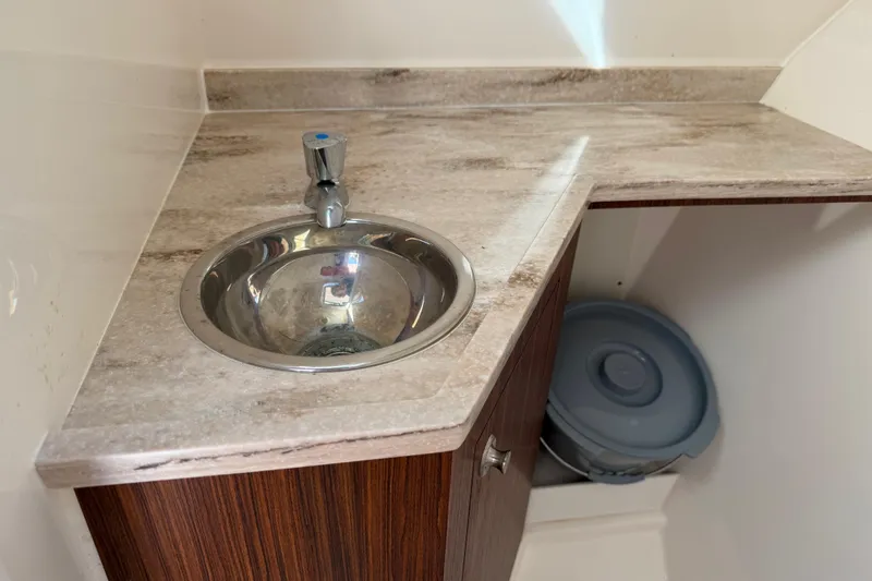 Slide: The Image of 2017 Pursuit DC 295 Dual Console boat interior with sink and countertop. - 54