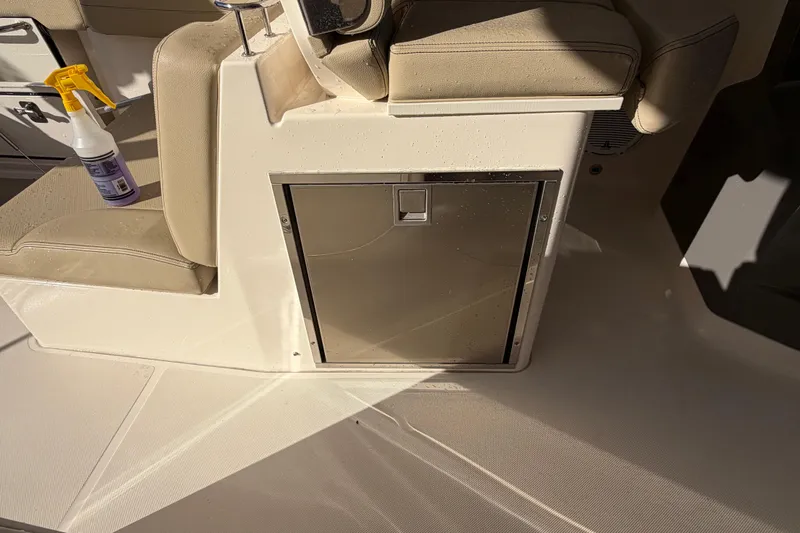 Slide: The Image of 2017 Pursuit DC 295 Dual Console interior with storage compartment and cleaning spray bottle. - 57