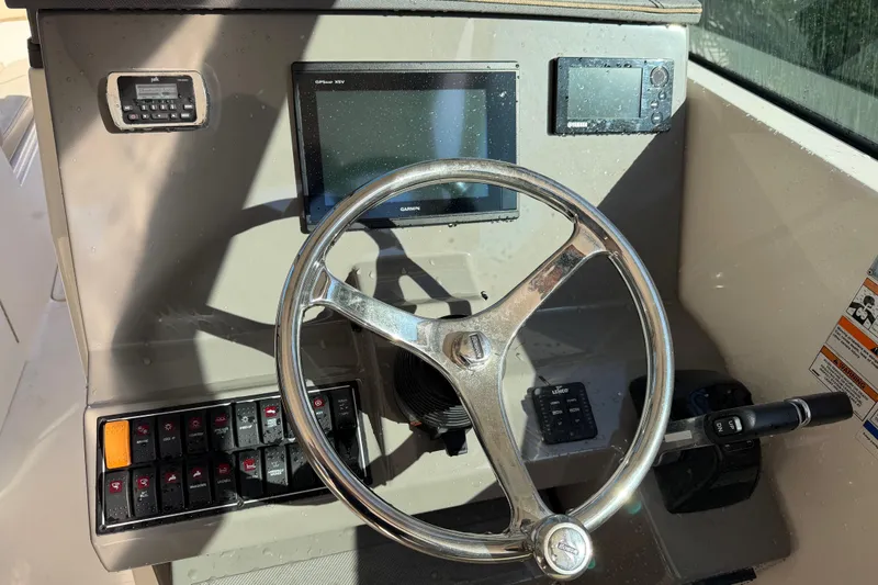 Slide: The Image of 2017 Pursuit DC 295 Dual Console boat dashboard with steering wheel and navigation controls. - 60