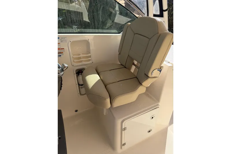 Slide: The Image of 2017 Pursuit DC 295 Dual Console boat seat with beige upholstery and storage compartment. - 61