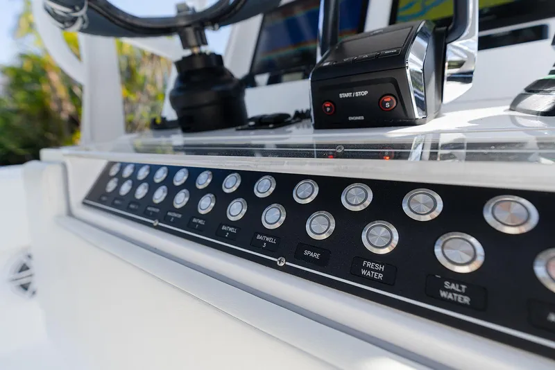 Slide: The Image of 2024 Invincible 33 Open Fisherman control panel with buttons and start/stop engine switch. - 12