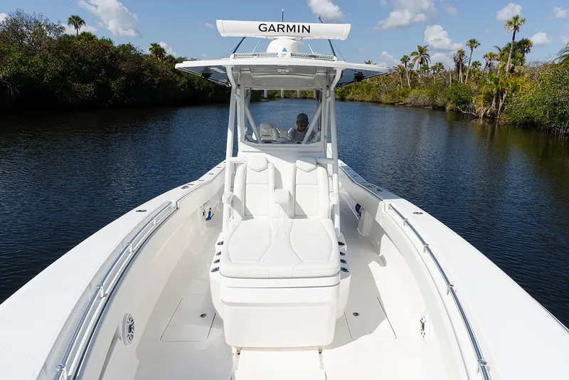 Slide: The Image of 2024 Invincible 33 Open Fisherman boat cruising on a scenic waterway. - 17