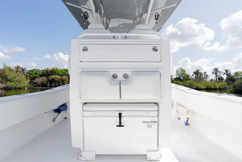 Slide: The Image of 2024 Invincible 33 Open Fisherman boat interior with storage compartments, under a clear blue sky. - 22