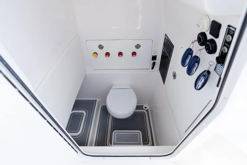 Slide: The Image of 2024 Invincible 33 Open Fisherman boat interior with toilet and control panel. - 24
