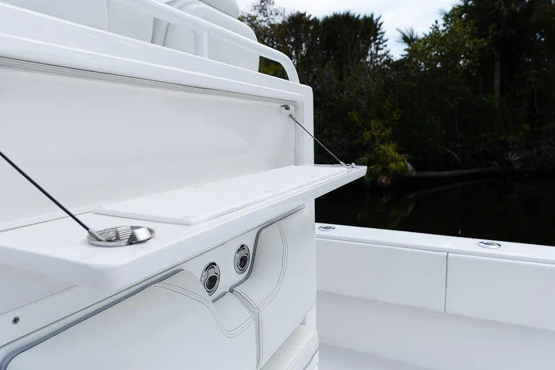 Slide: The Image of 2024 Invincible 33 Open Fisherman boat detail with sleek white design and storage compartment. - 39