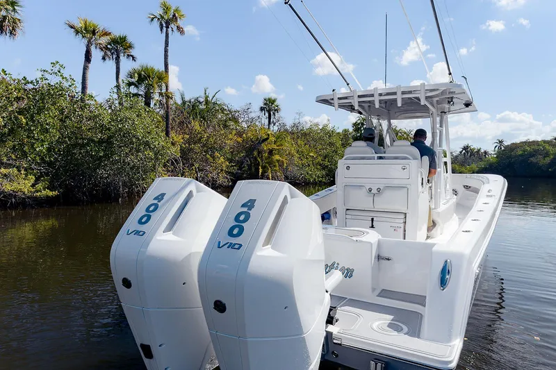 Slide: The Image of 2024 Invincible 33 Open Fisherman boat with dual 400 V10 engines in a scenic waterway. - 4