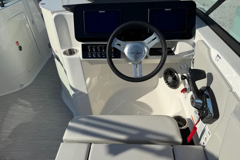 Slide: The Image of 2026 Sea Ray SDX 230 boat helm with steering wheel and control panel. - 15