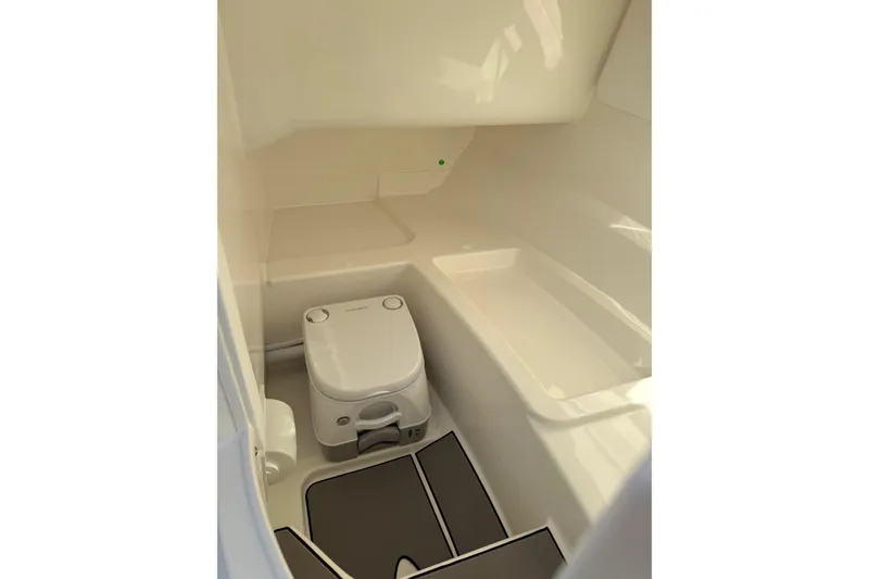 Slide: The Image of 2026 Sea Ray SDX 230 boat interior with compact toilet and storage area. - 16