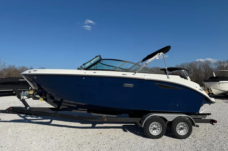 Slide: The Image of 2026 Sea Ray SDX 230 boat on trailer under clear blue sky. - 2