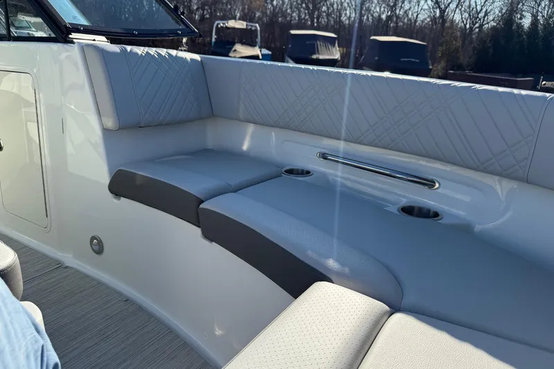 Slide: The Image of 2026 Sea Ray SDX 230 boat interior with cushioned seating and cup holders. - 9