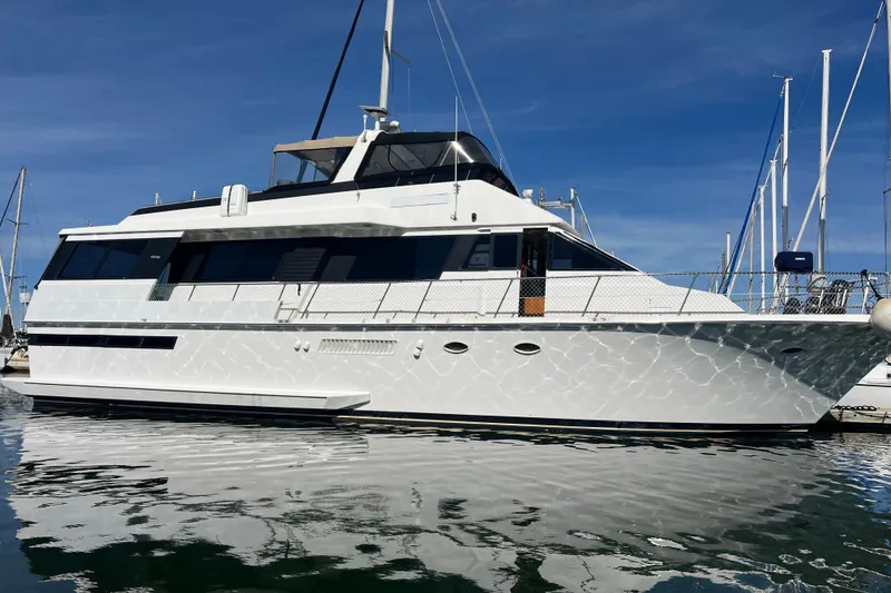 The Image of 1991 Viking 63 Motor Yacht docked in a marina under clear blue skies. - 0