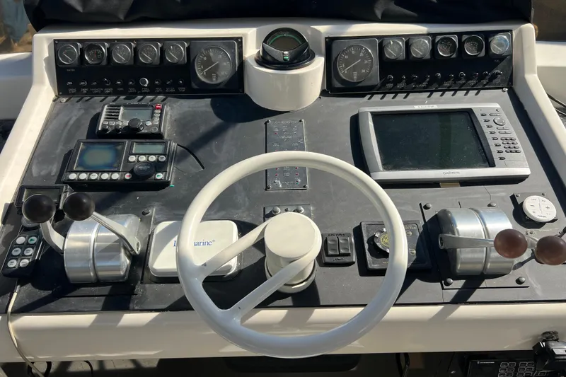 Slide: The Image of Cockpit view of 1991 Viking 63 Motor Yacht with marina backdrop. - 11