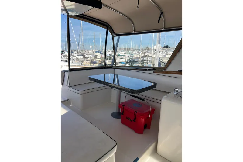 Slide: The Image of Interior view of a 1991 Viking 63 Motor Yacht helm with marina backdrop. - 14