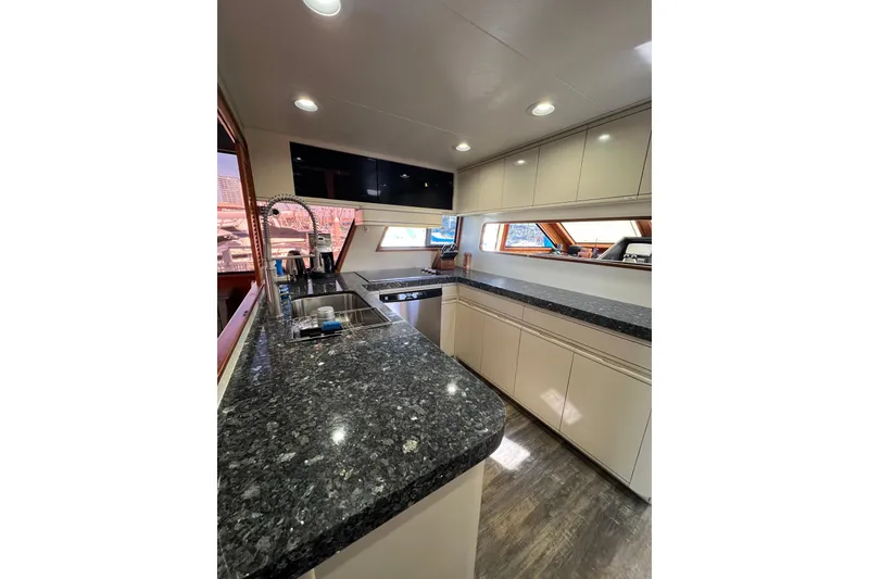 Slide: The Image of Luxurious kitchen interior of 1991 Viking 63 Motor Yacht with granite countertops and modern appliances. - 21
