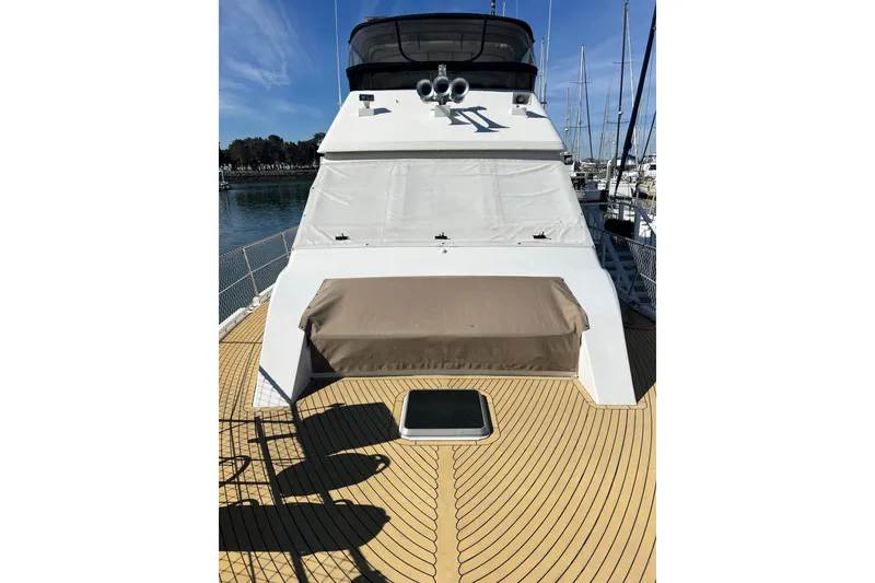 Slide: The Image of 1991 Viking 63 Motor Yacht docked, showcasing spacious deck and sleek design. - 7