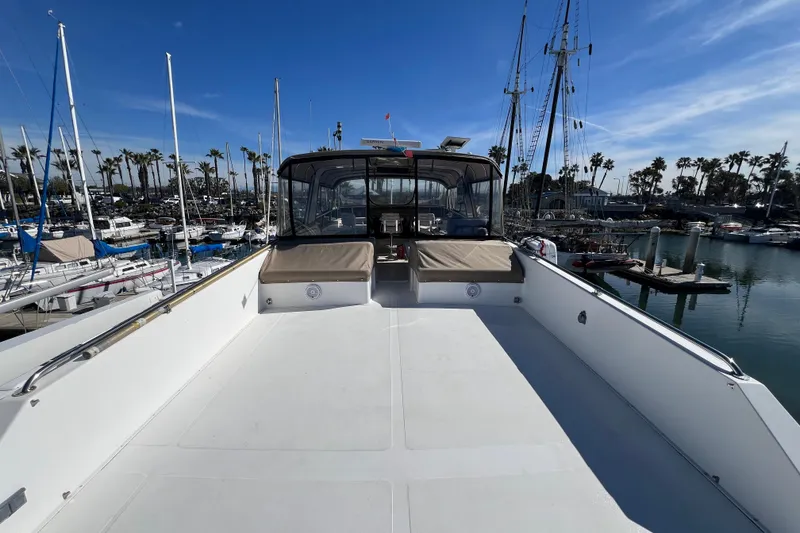 Slide: The Image of Viking 63 Motor Yacht 1991 at marina, clear sky, calm waters, sailboats docked nearby. - 9