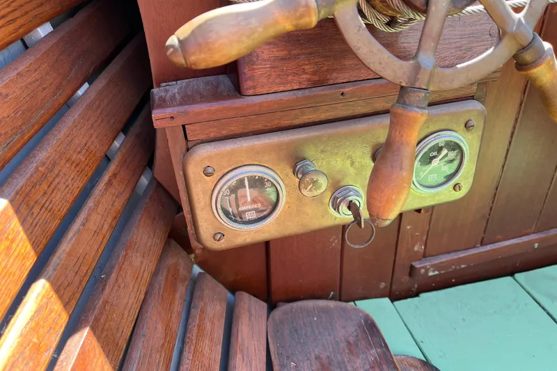Slide: The Image of Vintage 1938 yacht tender dashboard with wooden steering wheel and gauges. - 10