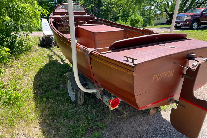 Slide: The Image of Vintage 1938 wooden yacht tender "Puffin" on trailer, surrounded by greenery. - 9