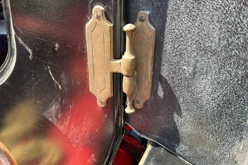 Slide: The Image of Close-up of a vintage brass hinge on a 1985 GONDOLA utility vehicle door. - 11