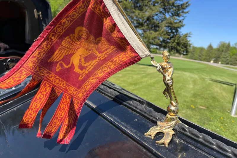 Slide: The Image of Golden figure holding a red flag with a lion emblem on a 1985 GONDOLA utility. - 5