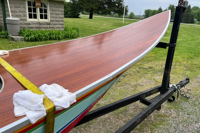 Slide: The Image of 1990 Thai Longboat utility model on trailer, wooden deck, outdoor setting. - 10