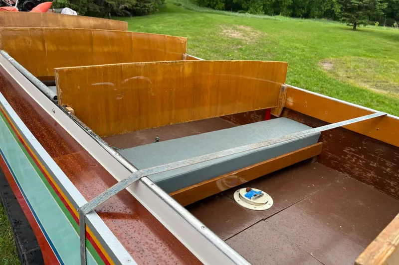 Slide: The Image of 1990 Thai Longboat utility model with wooden seats and colorful exterior, set in grassy area. - 5