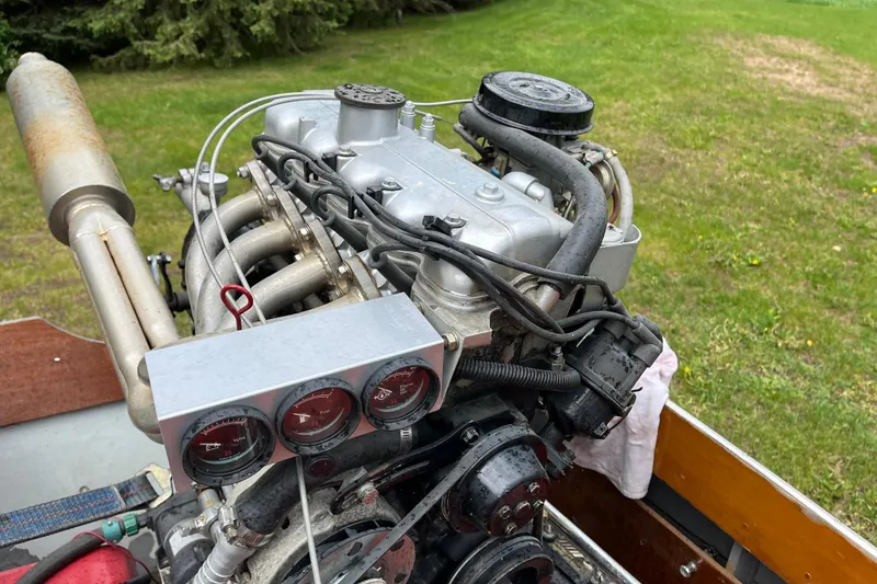 Slide: The Image of Close-up of a 1990 Thai Longboat utility engine with gauges, set against a grassy background. - 9