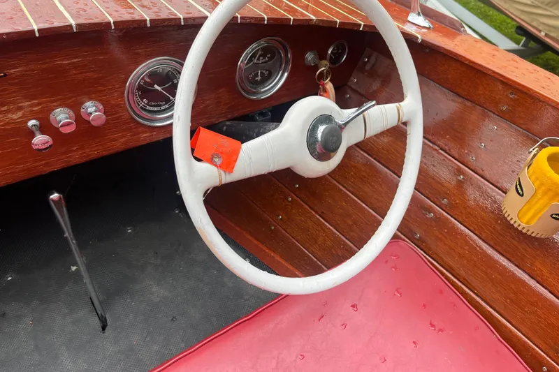 Slide: The Image of 1956 Chris-Craft 17 Sportsman boat interior with wooden dashboard and white steering wheel. - 12