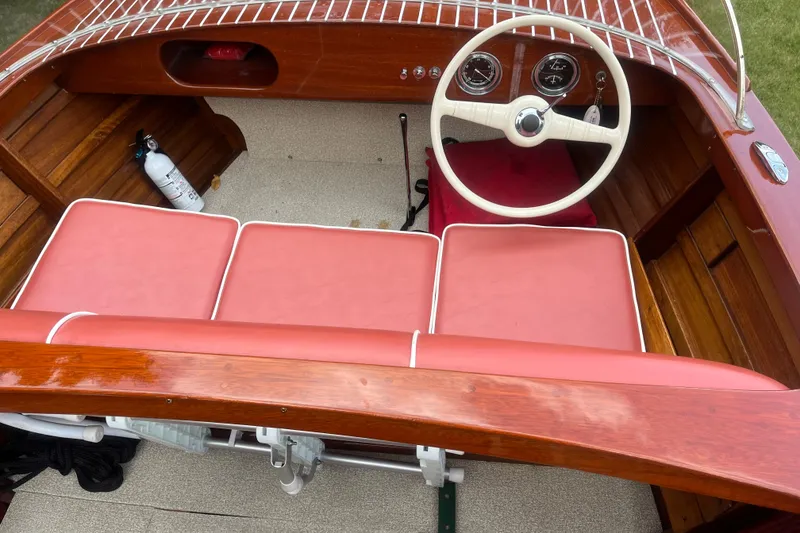 Slide: The Image of 1955 Chris-Craft 17 Sportsman boat interior with red seats and classic steering wheel. - 10