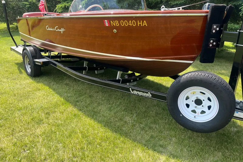 Slide: The Image of 1955 Chris-Craft 17 Sportsman boat on trailer, displayed on grass with American flag. - 4