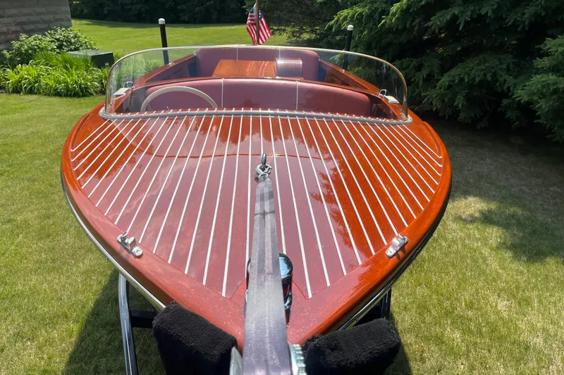 Slide: The Image of 1955 Chris-Craft 17 Sportsman boat with polished wood finish and American flag. - 7