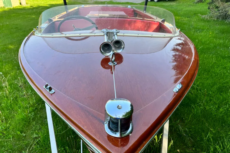 Slide: The Image of 1958 Chris-Craft 16 Cavalier boat with polished wood finish and chrome details on grass. - 3